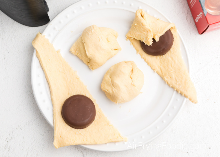 Tagalong cookies being wrapped in crescent dough.