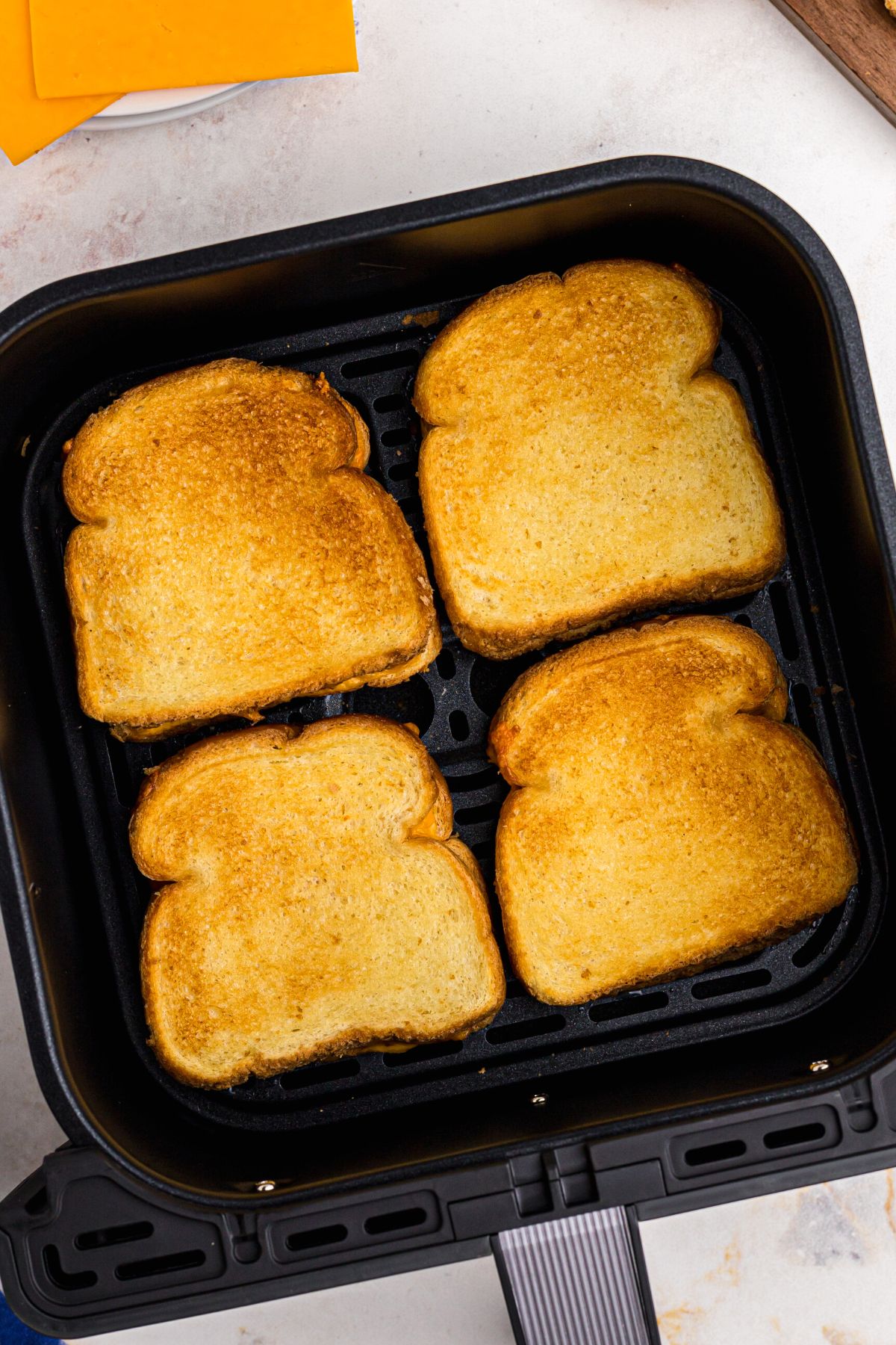 golden crispy grilled cheese sandwiches in the air fryer basket