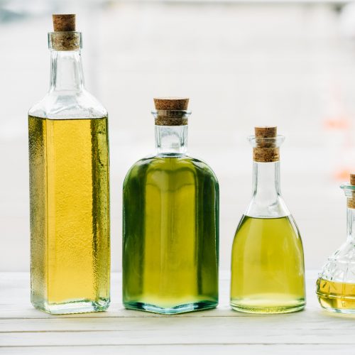 Different oils in bottles on a counter top.