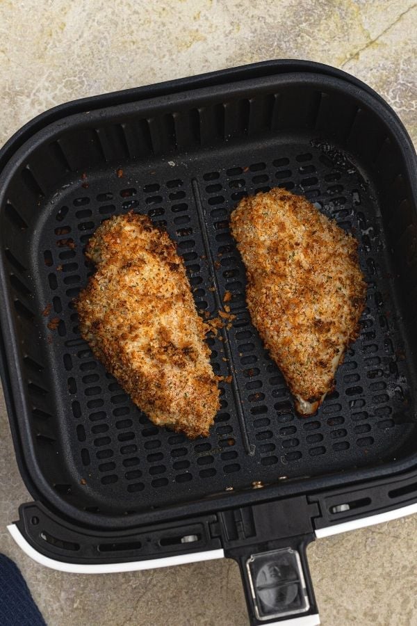 Cooked crusted chicken in the air fryer basket. 