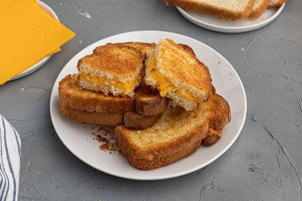 Crispy grilled cheese sandwich on a white plate