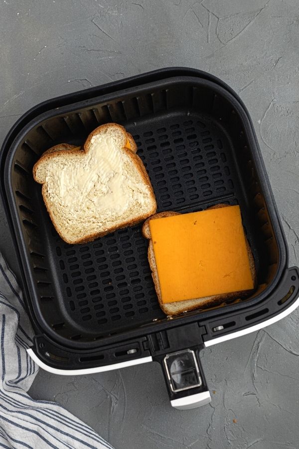 Uncooked bread and cheddar cheese slice, in the basket. 