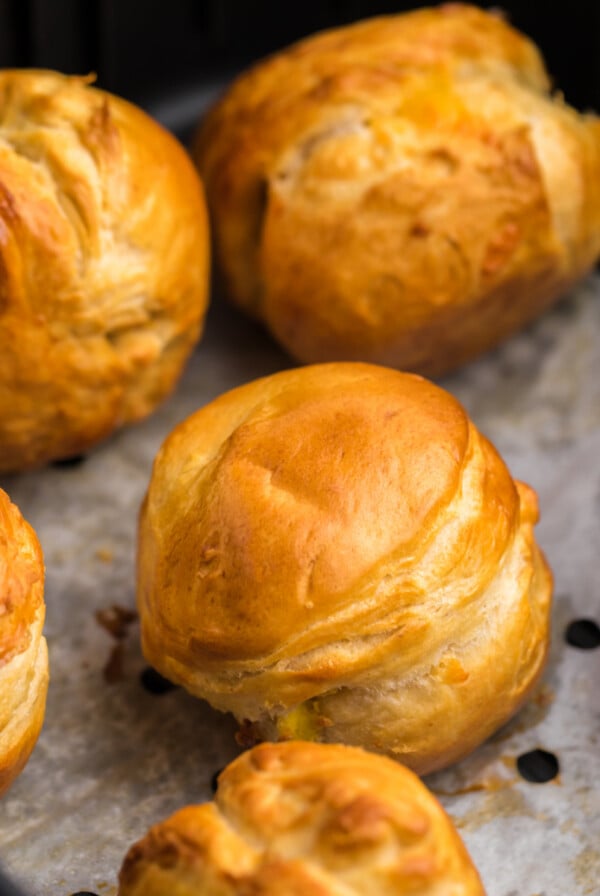 Air Fryer Biscuit Bombs on parchment paper in the basket of the Air Fryer.