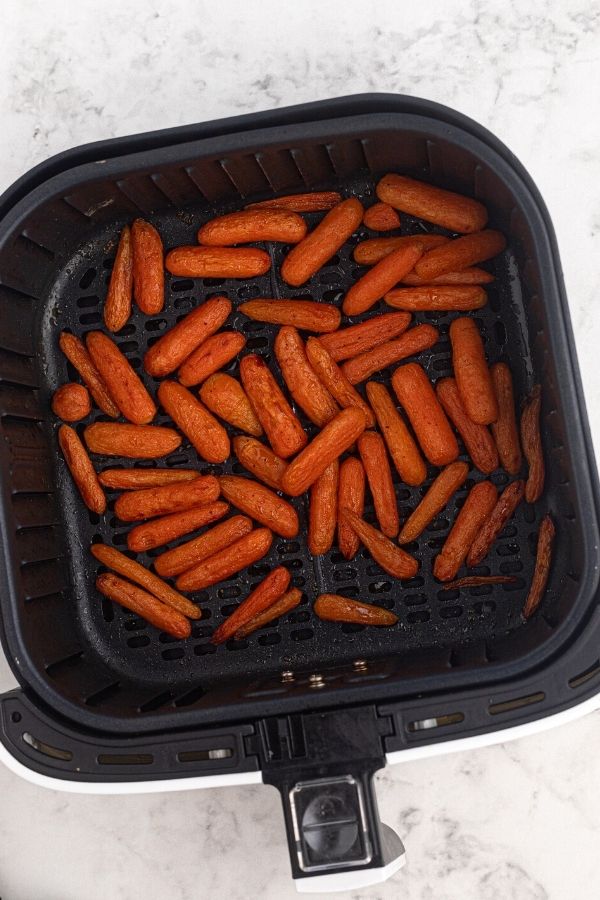 Cooked honey glazed carrots in the air fryer basket. 
