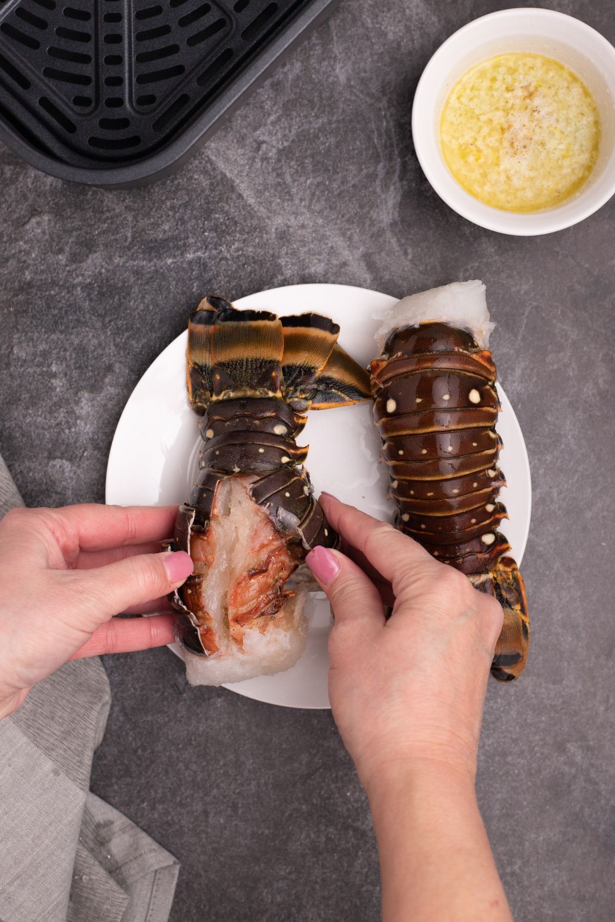 Lobster shells cut open and being pulled apart to get to meat.