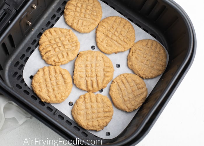 Peanut Butter cookies on a piece of parchment paper in the Air Fryer basket. 