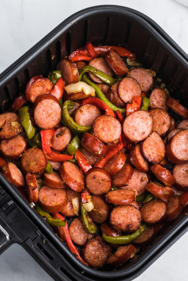 Sausage and peppers in an Air Fryer basket.