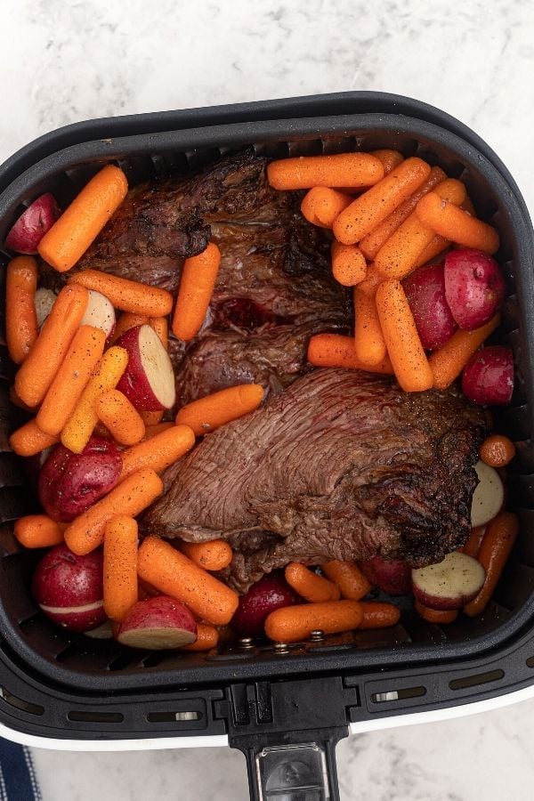 Roast in the air fryer basket, cooking with potatoes and carrots. 