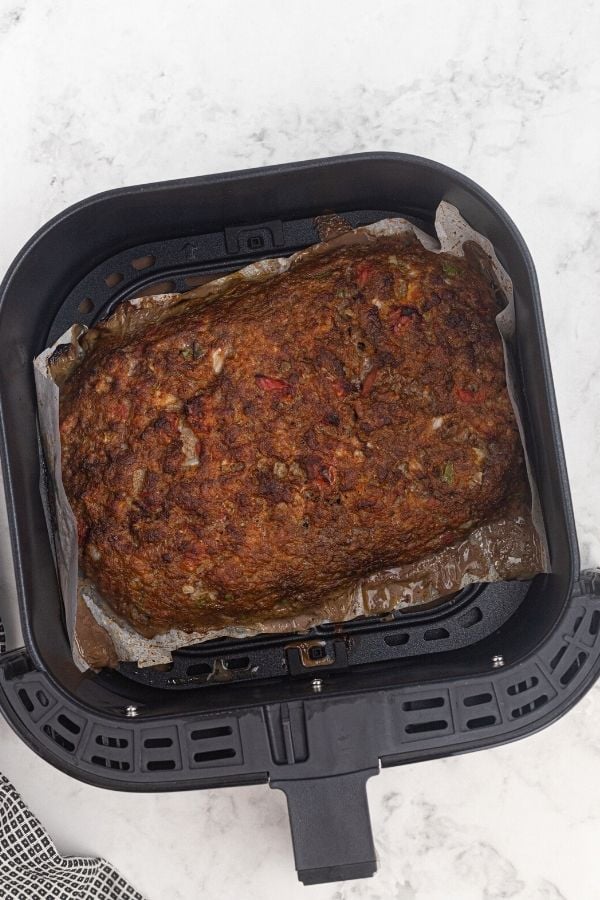 Cooked meatloaf in the air fryer basket. 