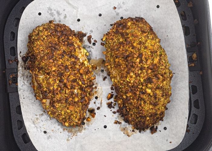 Pistachio Crusted chicken in the air fryer basket, before after cooked. 