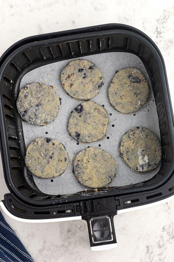 Uncooked blueberry scones in an air fryer basket. 