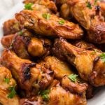 BBQ Chicken Wings stacked on a white serving tray that have been cooked in the Air Fryer.