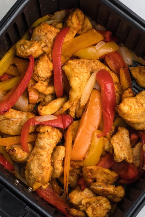 chicken fajitas in air fryer basket ready to serve.