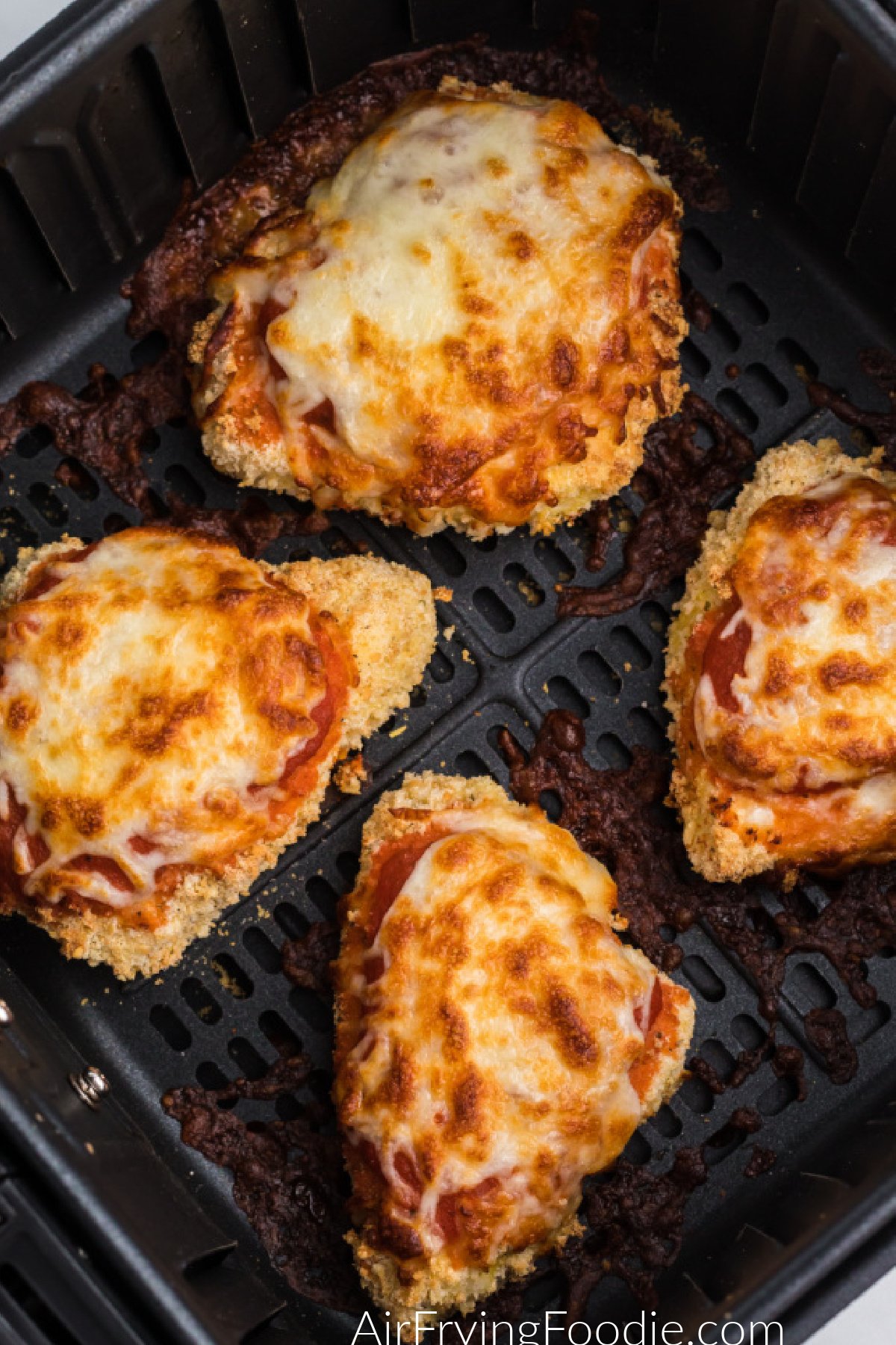 Chicken parmesan in basket of air fryer ready to serve.