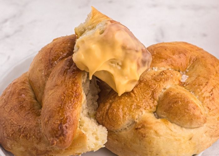 golden soft air fryer pretzel sprinkled with sea salt, and dipped into melted cheddar cheese.
