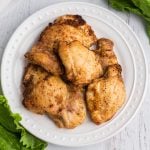 overhead photos of chicken thighs fully cooked in the air fryer and served on a white plate.