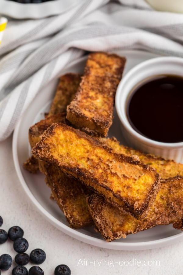 Close up of french toast sticks on a white plate ready to serve.