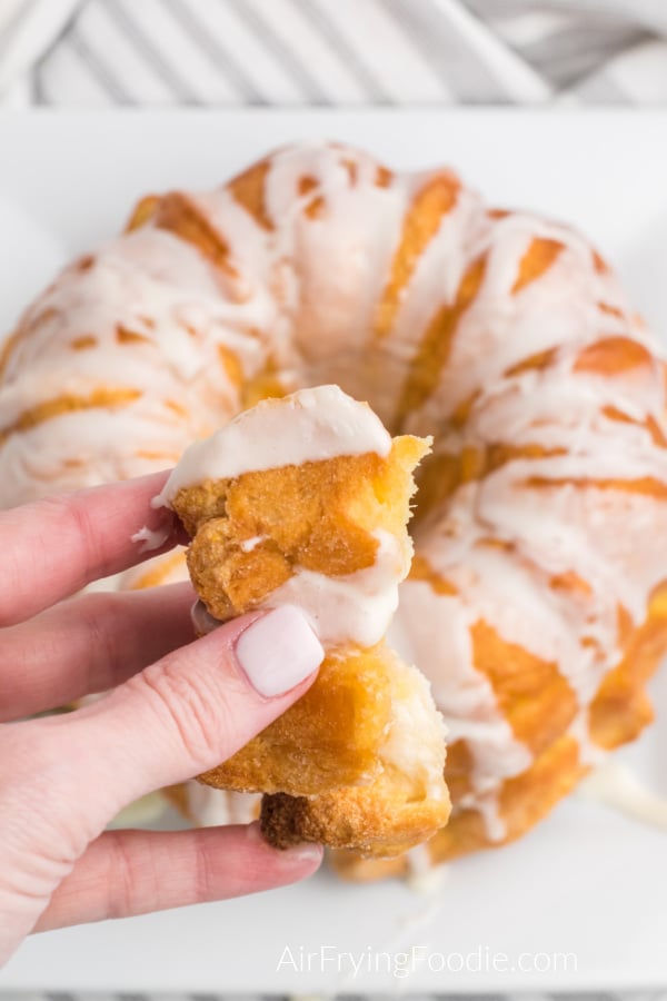 Hand holding a bite of Air Fryer Monkey Bread. 