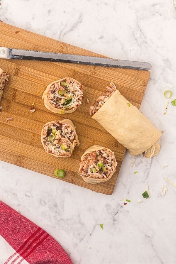 Air Fryer BBQ Chicken Pizza Rolled dough filled and then cut into circles on a cutting boards.