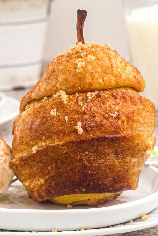 Golden glazed pear wrapped in puff pastry served with vanilla ice cream.