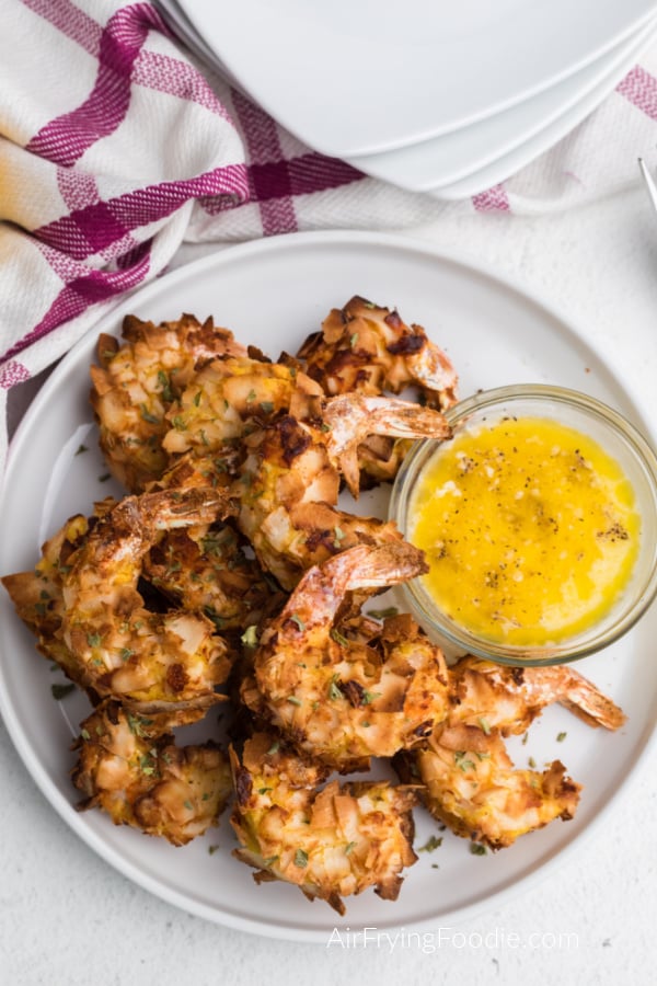Air Fried Coconut Shrimp on a white plate with butter sauce for dipping. 