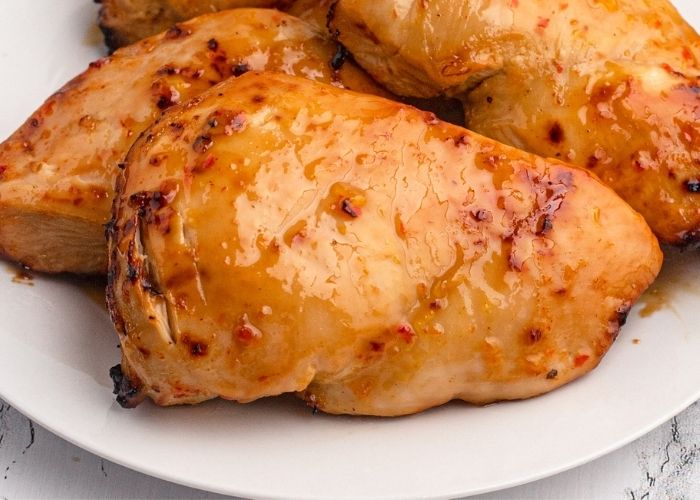 Juicy and moist glazed chicken served on a white plate.