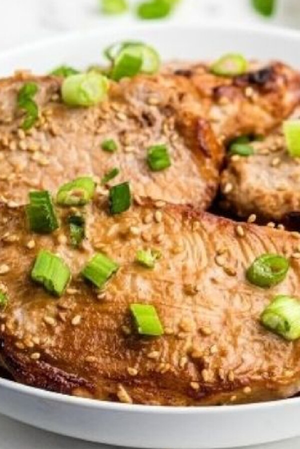 teriyaki pork chops on a white plate.