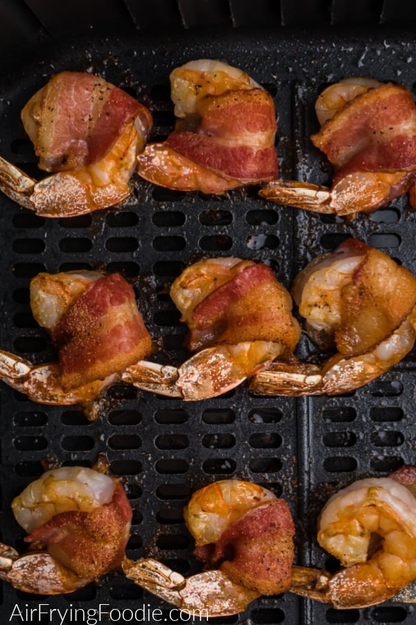 Bacon wrapped shrimp fully cooked in the basket of the air fryer. 