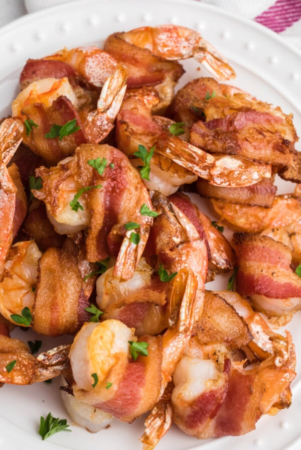 Overhead shot of bacon wrapped shrimp made in the air fryer and topped with fresh parsley.