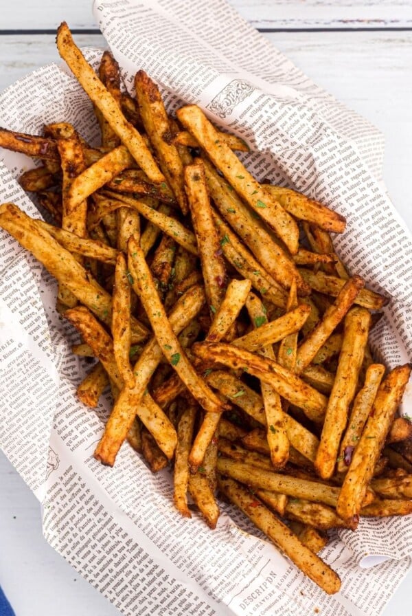 Golden crispy fries seasoned with salt pepper and more.