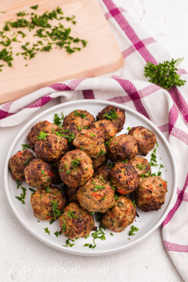 Turkey Meatballs made in the air fryer, on a white plate and garnished with parsley. 