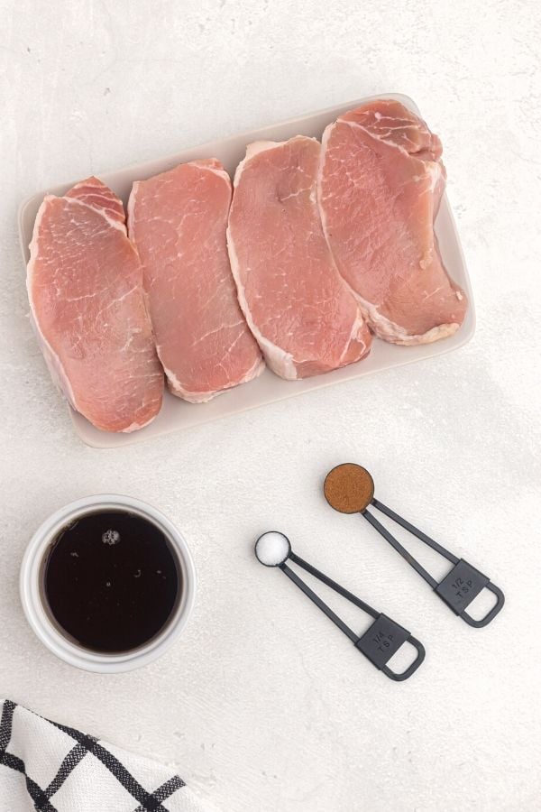 Ingredients to make maple glazed pork chops on a white table
