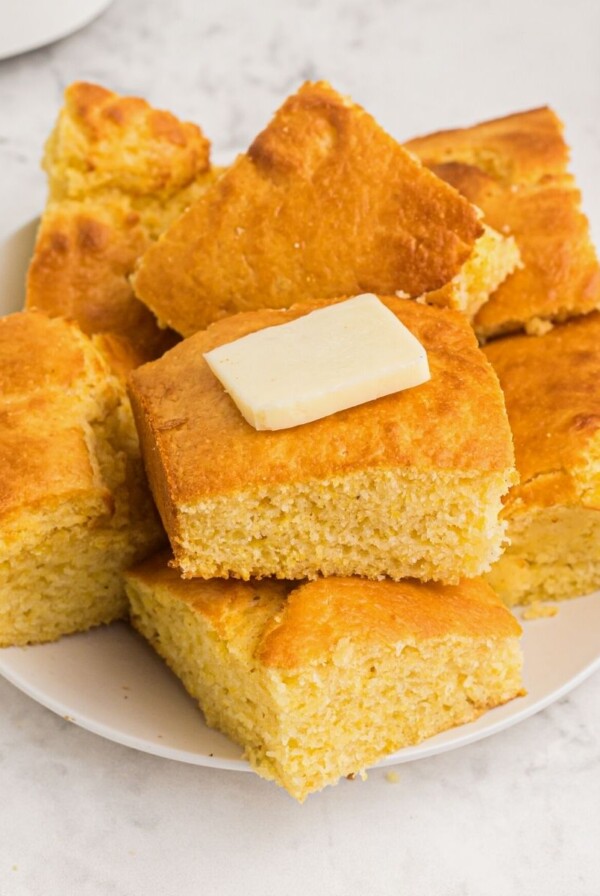 Cornbread on a white plate with butter on top