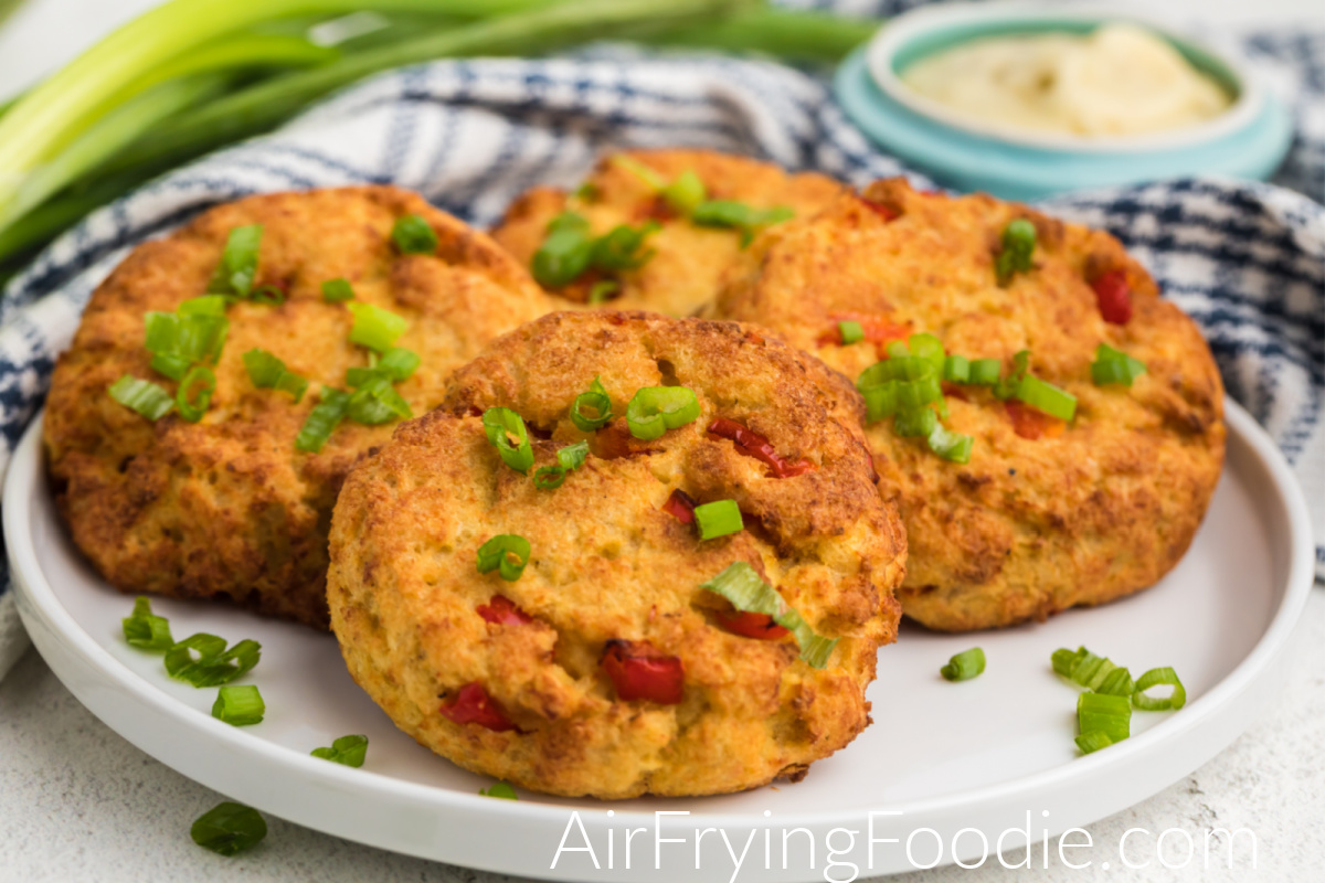 Air Fried Crab Cakes on a white plate garnished with green onion tops. 