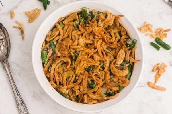 Golden fried onions on top of green bean casserole in a white pyrex dish. 