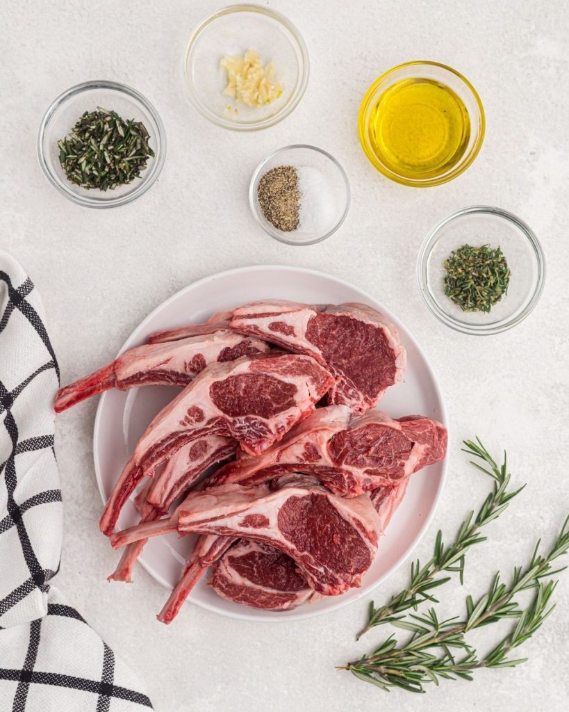 Ingredients needed to make lamb chops, olive oil, rosemary, thyme, salt, pepper, and garlic. 