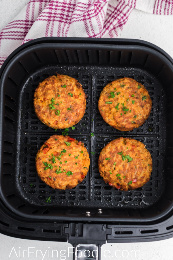 Air Fryer salmon cakes in the basket of the air fryer. 