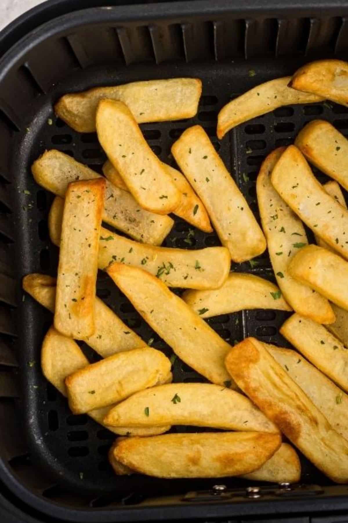 Crispy steak fries in the air fryer basket after being cooked