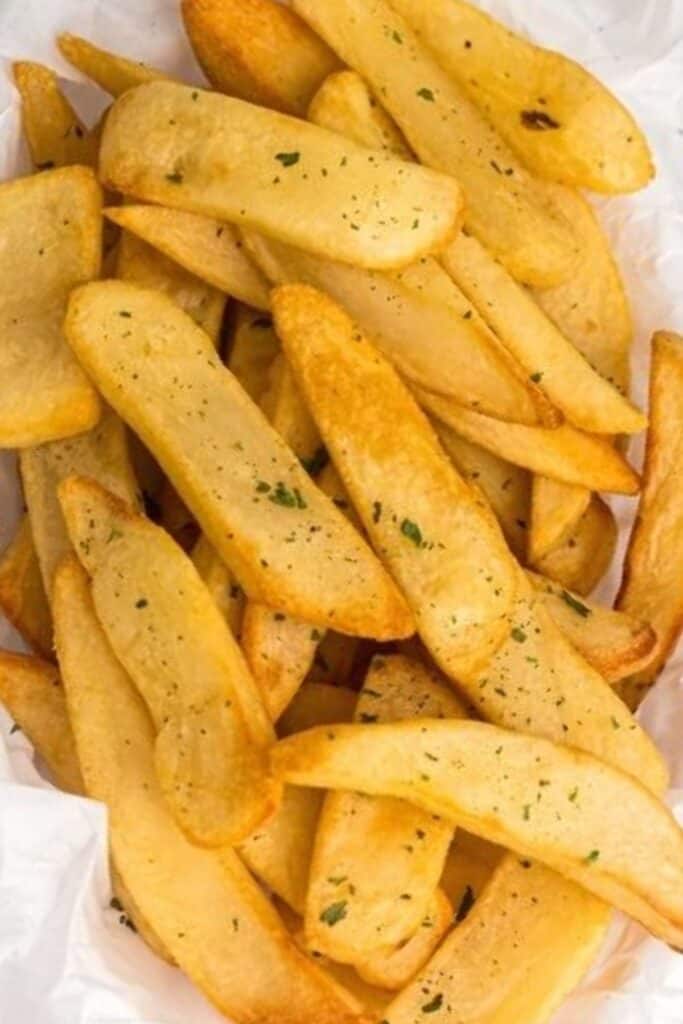 Crispy, golden steak fries stacked in a bowl after being cooked and seasoned. 