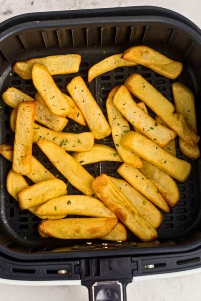 Crispy steak fries in the air fryer basket after being cooked