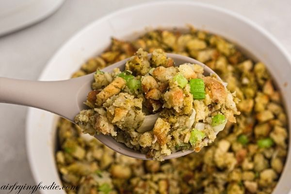 Golden stuffing in a spoon with celery and onion. 