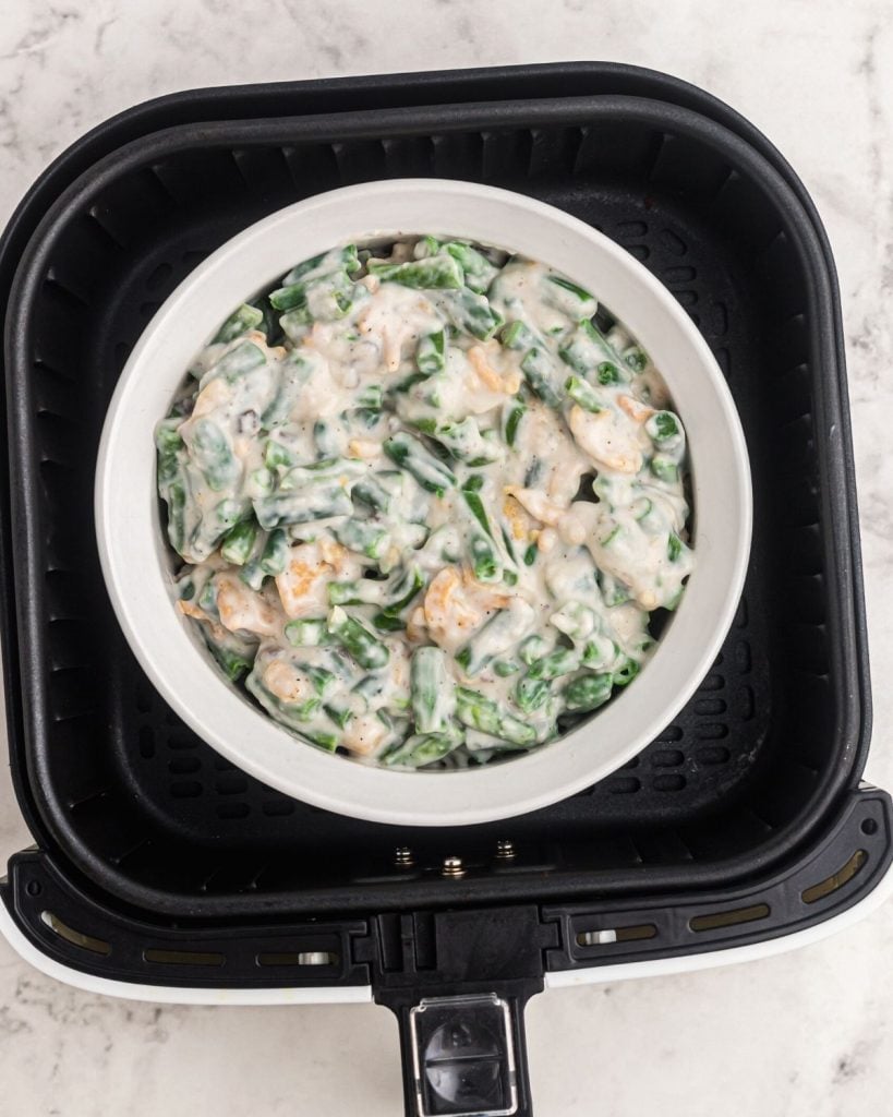 Casserole before being cooked in a pyrex dish in the air fryer basket. 