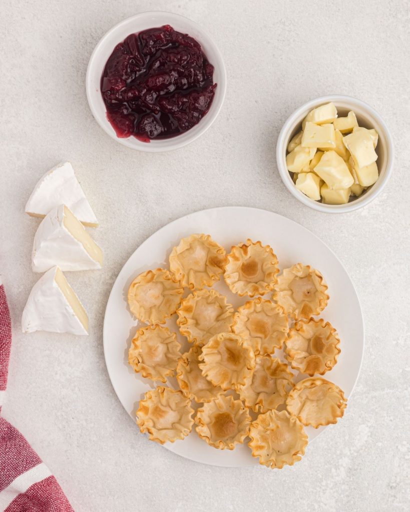 ingredients needed to make brie bites, phyllo shell cups, brie cheese, and cranberries. 
