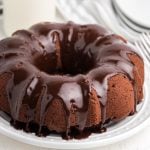 Chocolate Bundt Cake on a white plate and topped with chocolate frosting.
