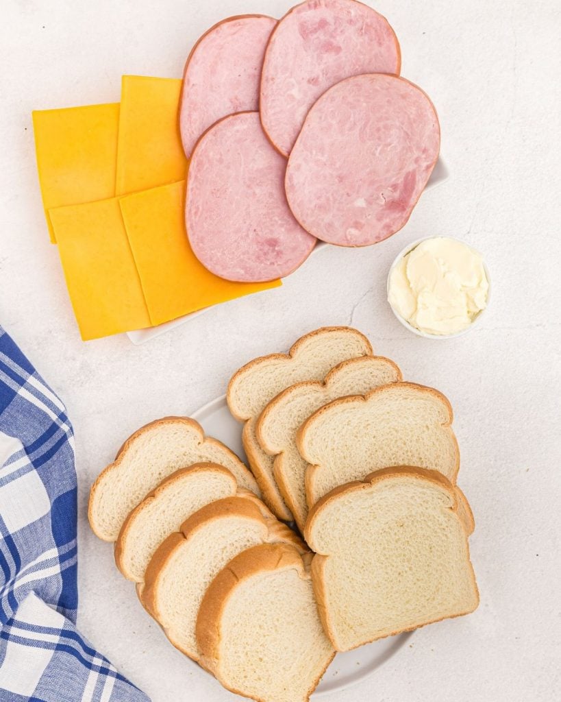 Ingredients needed to make ham and cheese sandwiches in the air fryer, bread, ham, cheese, butter. 
