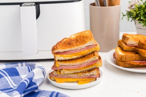Golden crispy ham and cheddar cheese sandwiches made in the air fryer basket. 