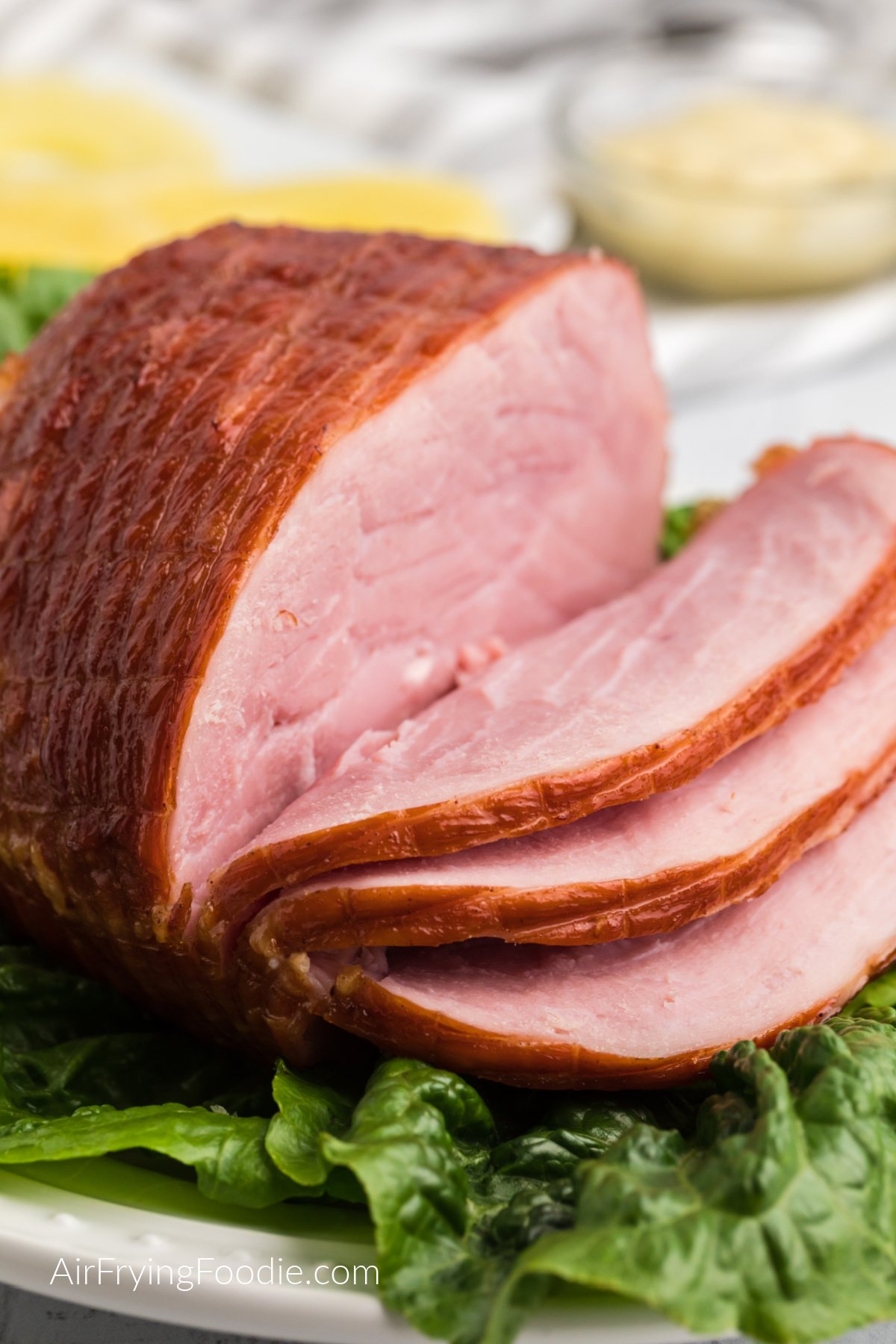 Fully cooked air fryer ham on a plate, sliced, and ready to serve.