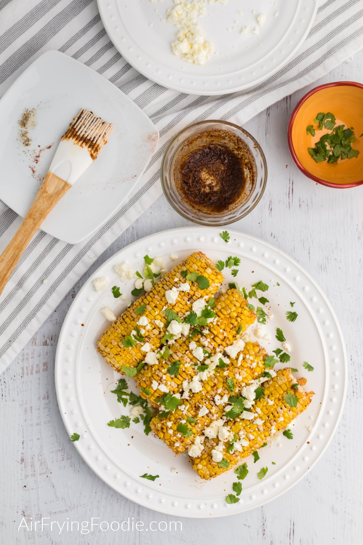 Cooked corn topped with feta cheese and fresh chopped cilantro.