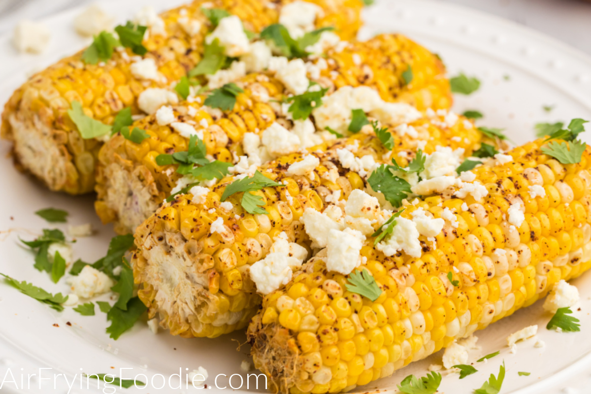 Close up photo of air fryer Mexican street corn on a white plate ready to eat. 