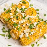 Close up of air fryer Mexican street corn on a white plate ready to serve.
